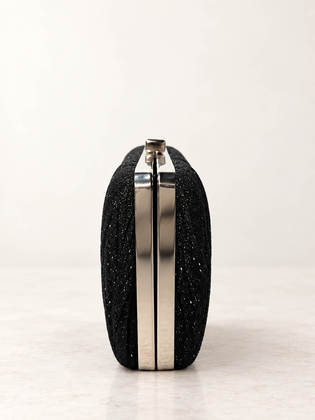Clutch negro para mujer vista lateral con estructura metálica