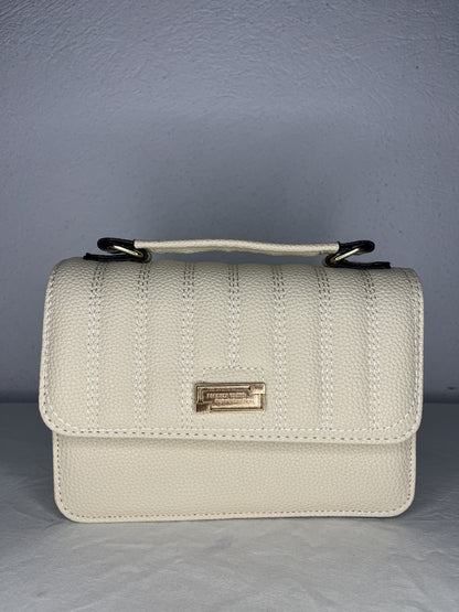 detalle frontal del bolso beige con herraje dorado
