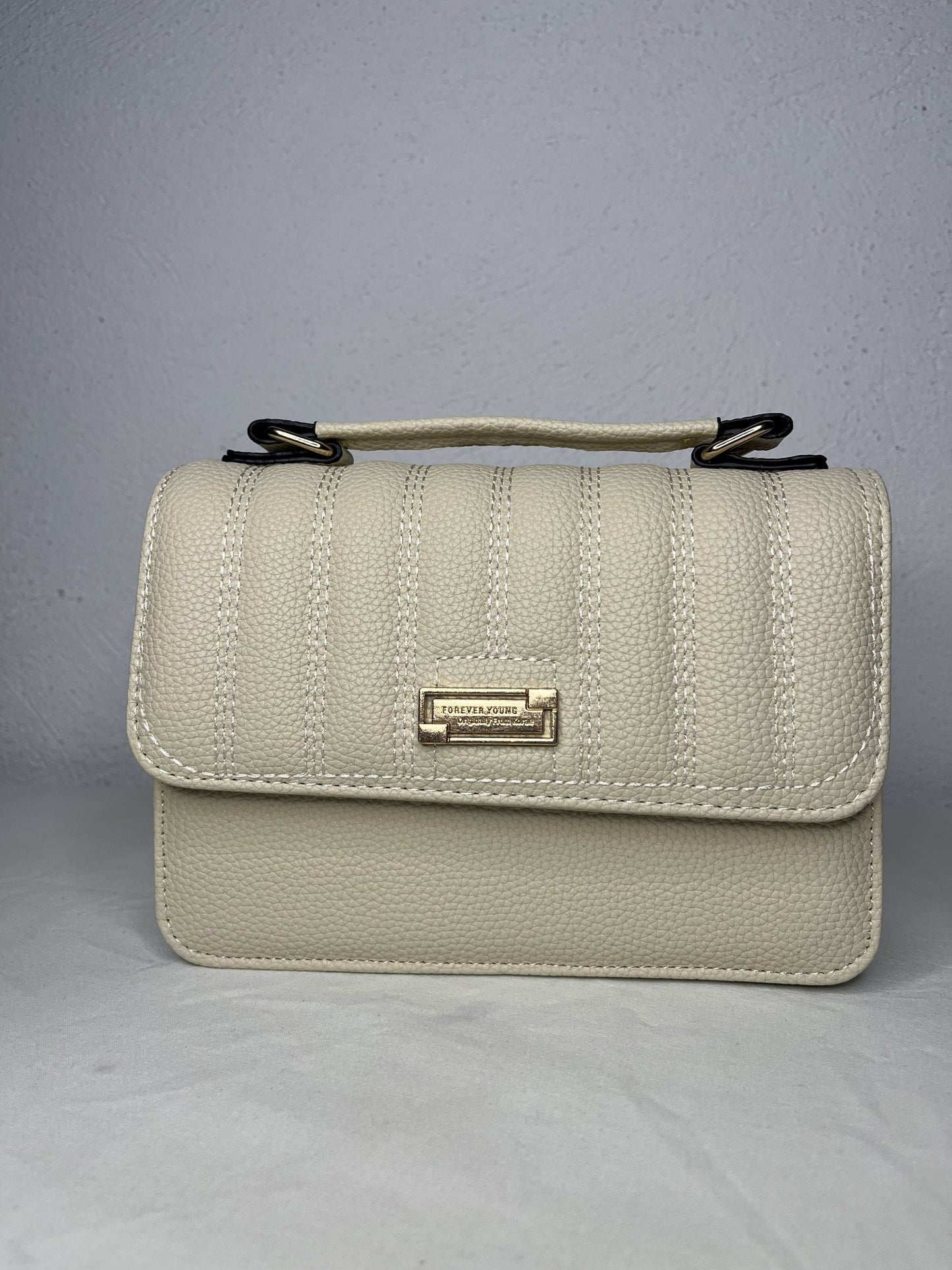 vista lateral del bolso beige acolchado elegante
