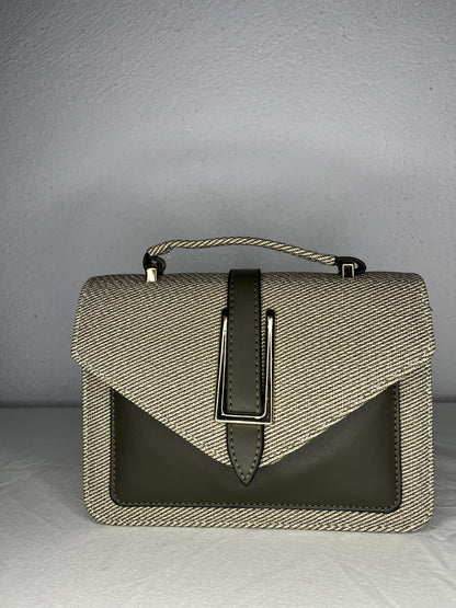 detalle frontal del bolso con herraje metálico decorativo
