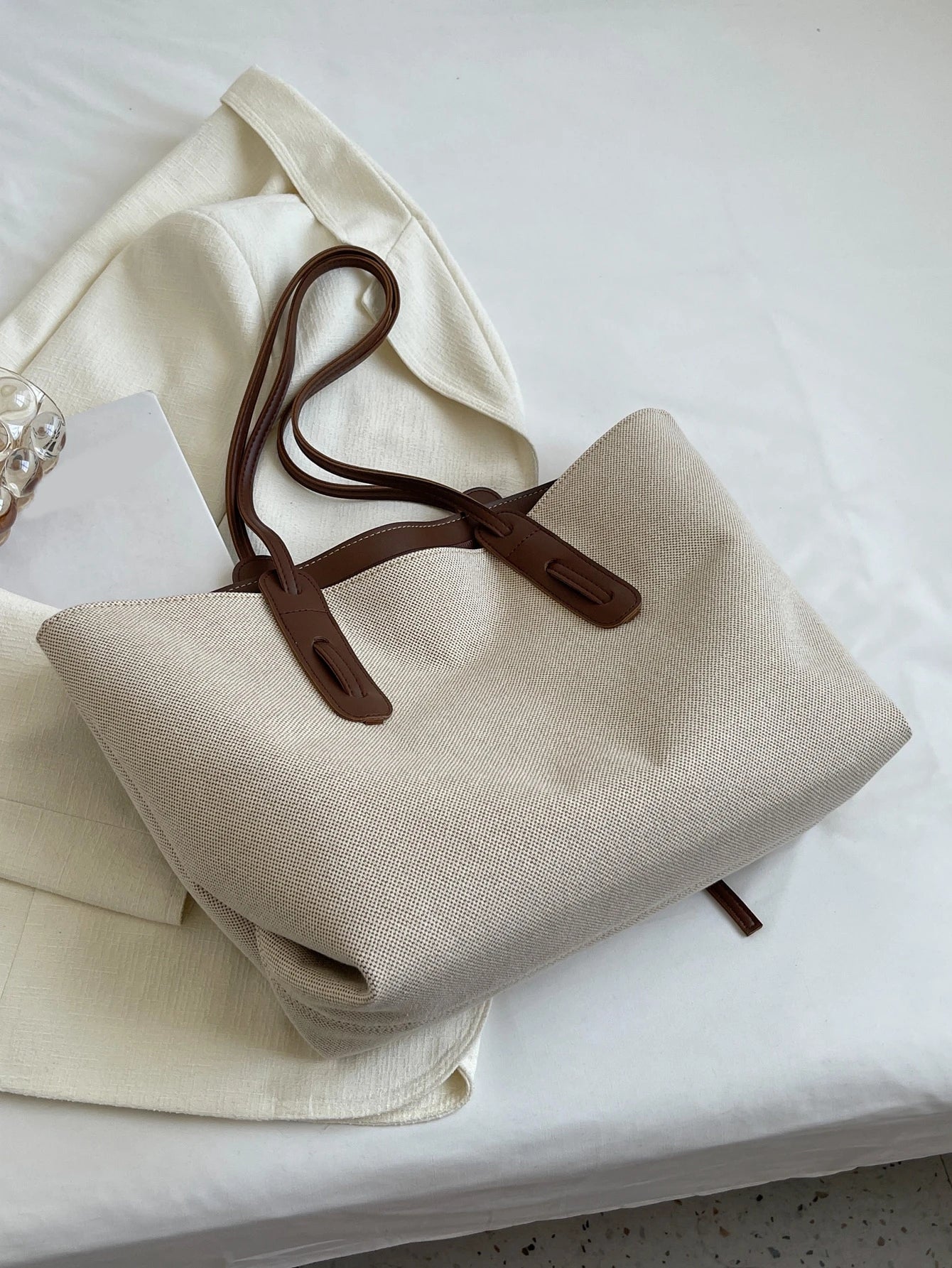 vista lateral del bolso beige con acabado texturizado
