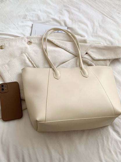 bolso tote beige para mujer sobre cama con diseño minimalista