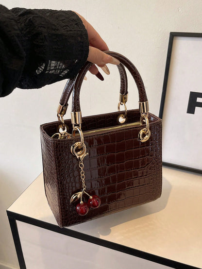bolso café croco para dama con colgante de cereza