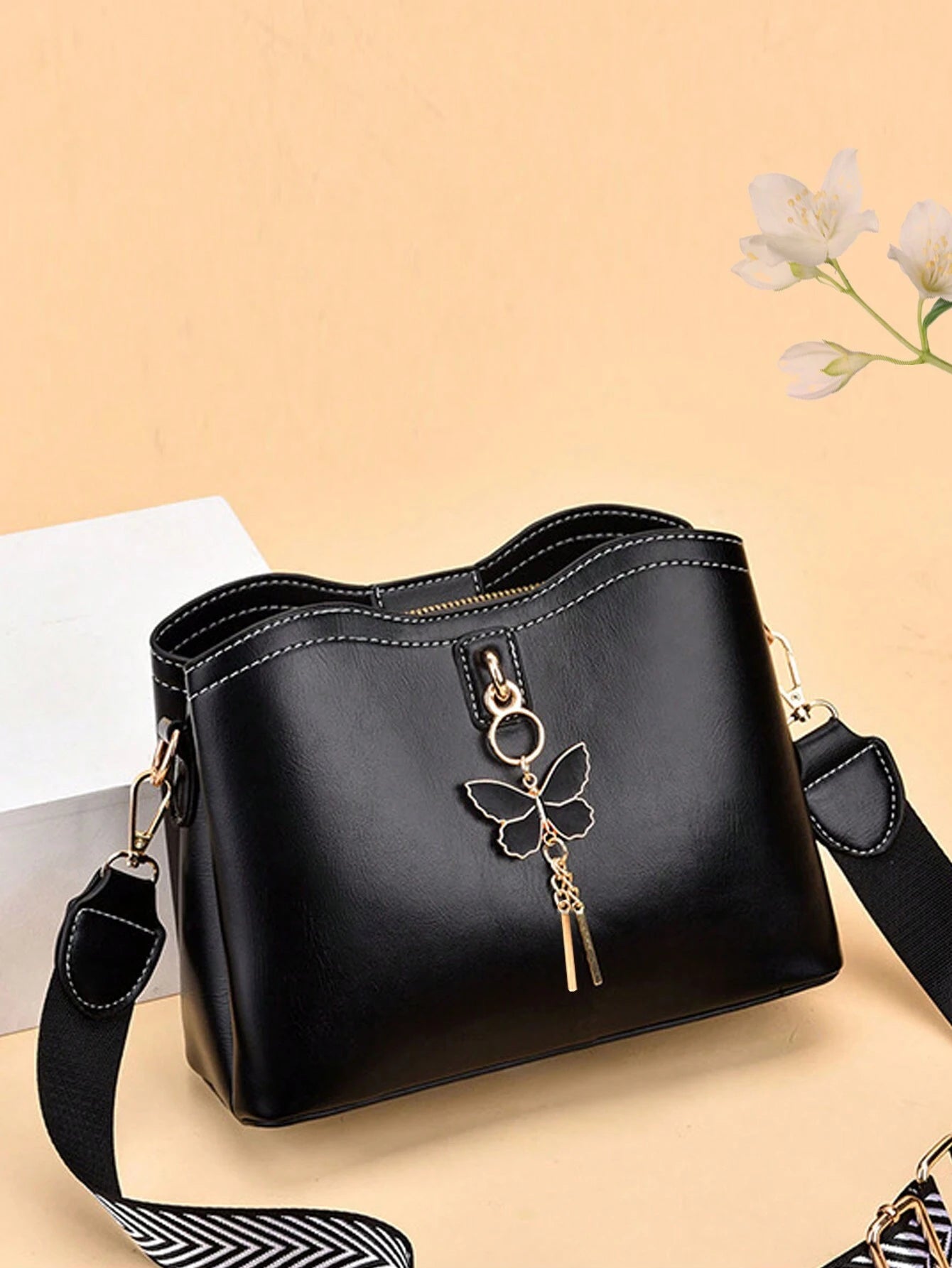 bolso negro crossbody para dama con detalle de mariposa