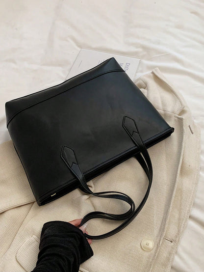 Bolso tote negro para mujer vista trasera sobre fondo claro