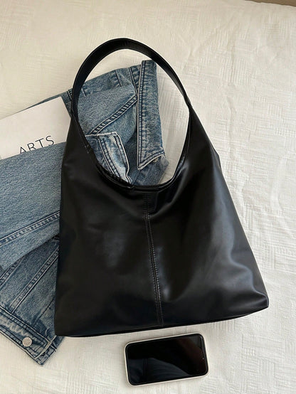 Bolso hobo negro para mujer junto a teléfono y prendas casuales