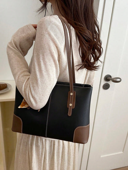 Bolso tote negro para mujer llevado al hombro vista lateral