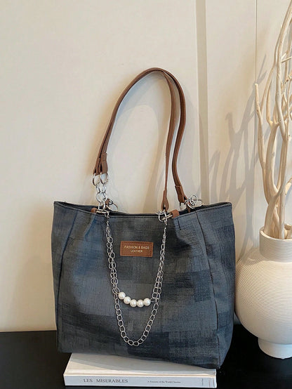 Bolso tote negro para mujer con cadena y perlas vista frontal