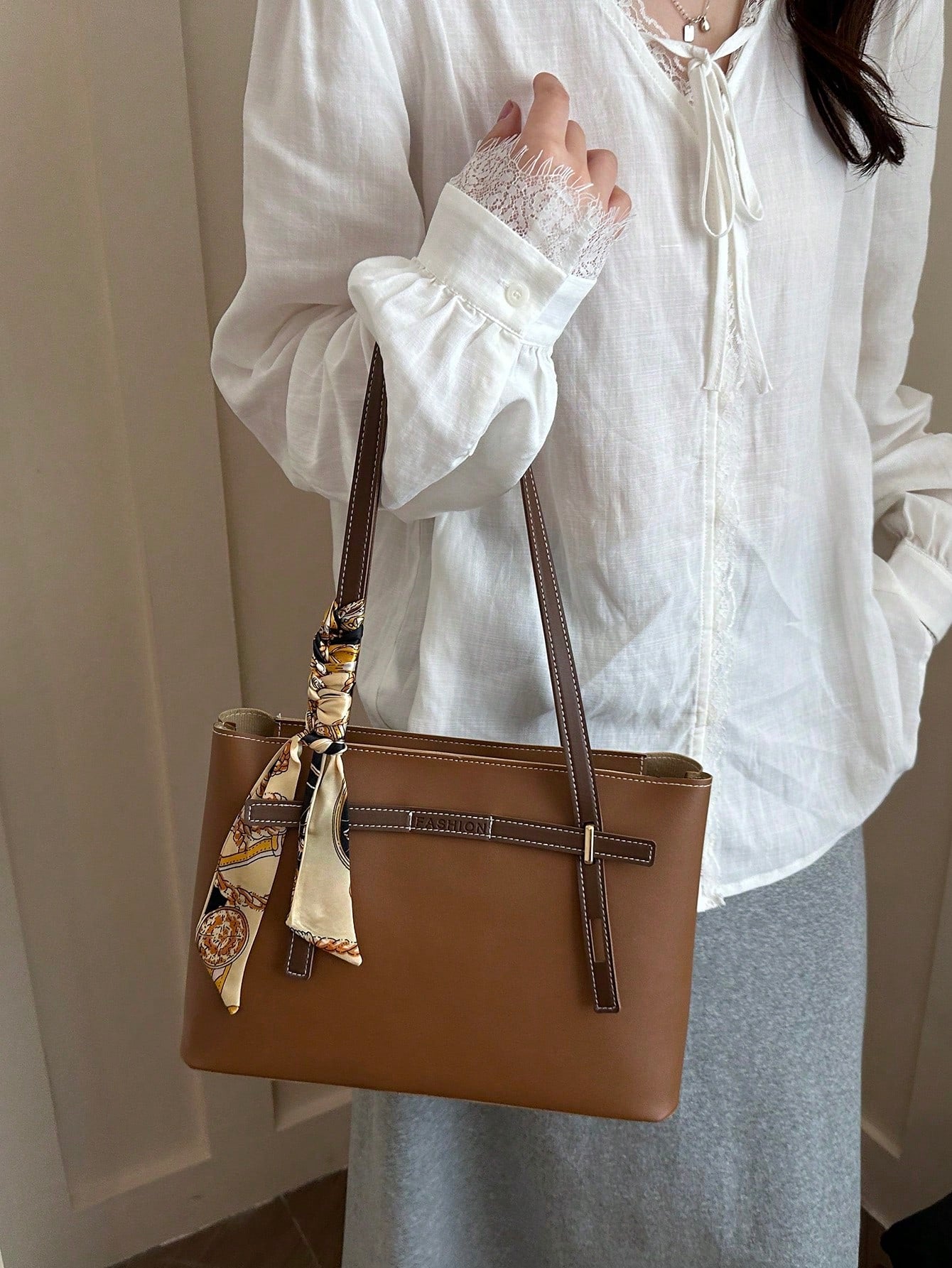 Bolso tote marrón para mujer llevado en la mano