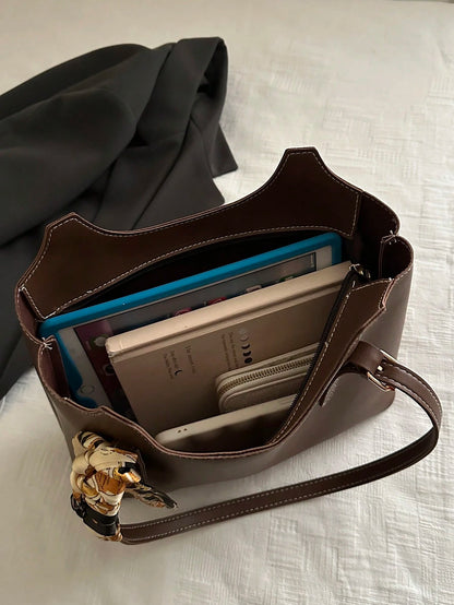 interior del bolso marrón mostrando compartimentos amplios