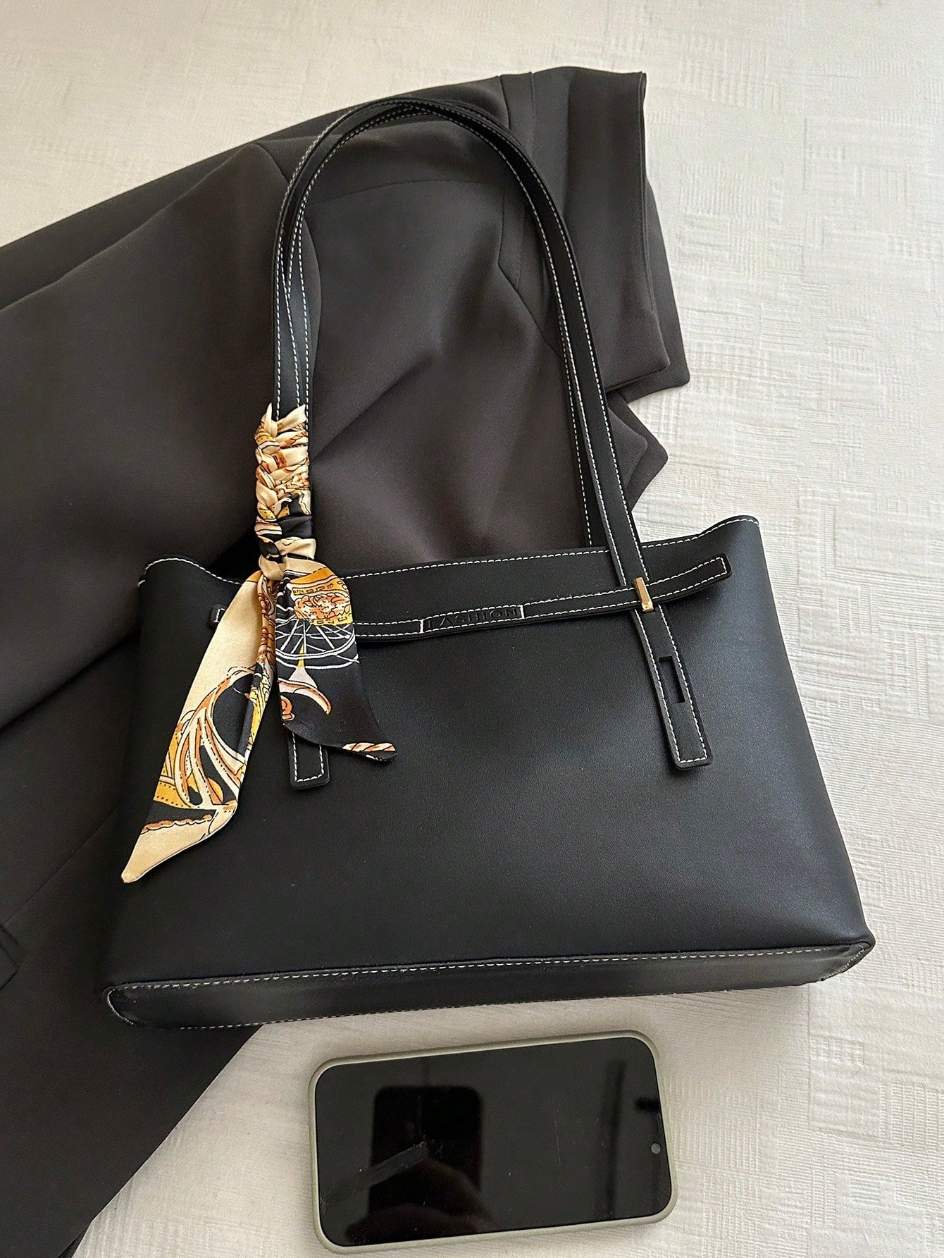 bolso tote negro para mujer vista superior sobre superficie clara
