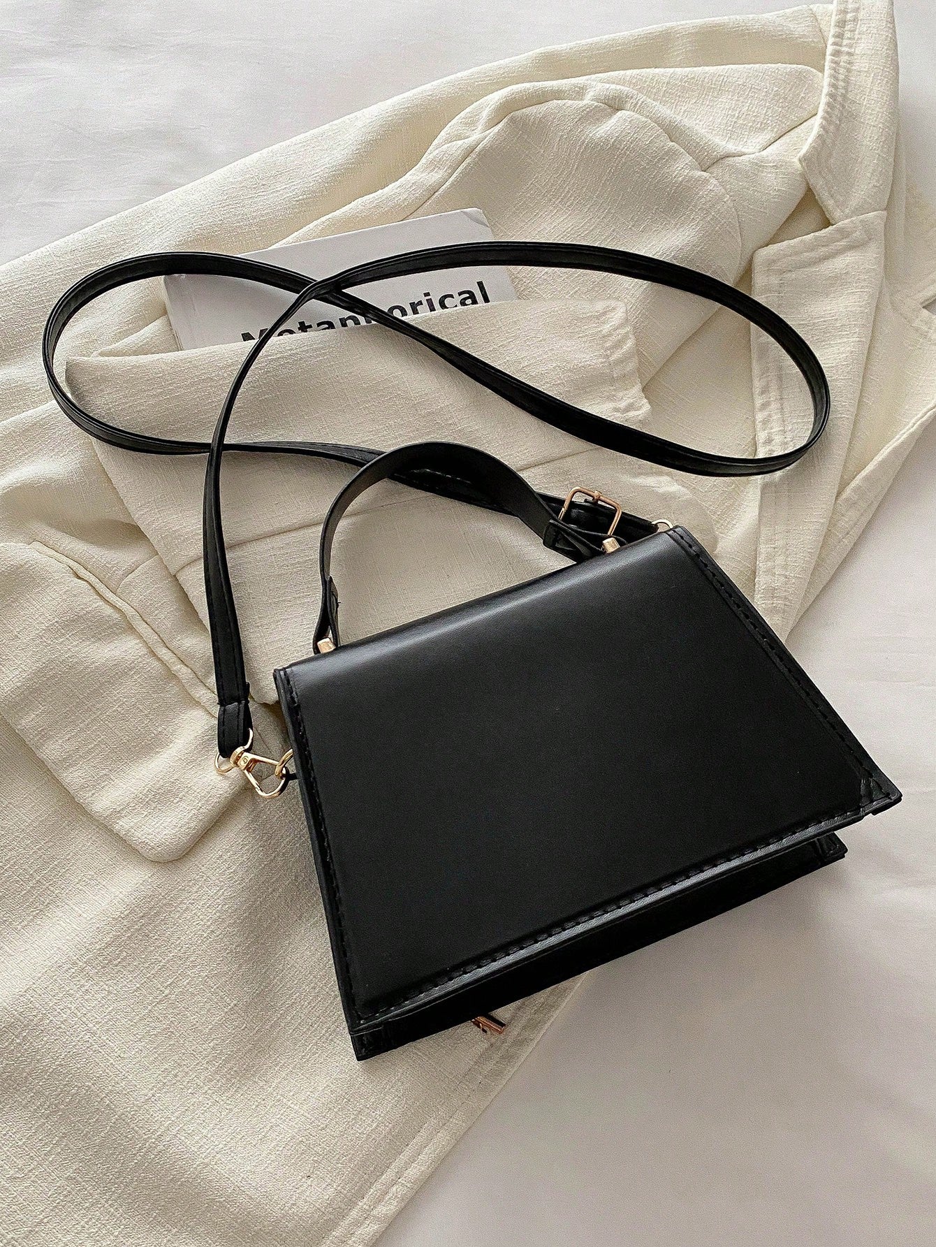 vista posterior del bolso negro cuadrado con correa ajustable