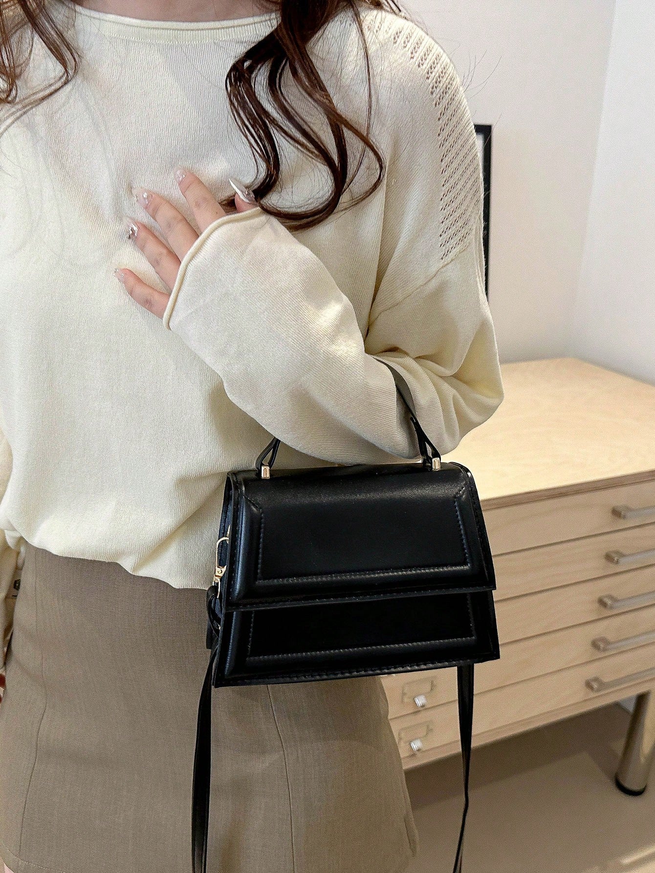 bolso negro mini usado al hombro por modelo