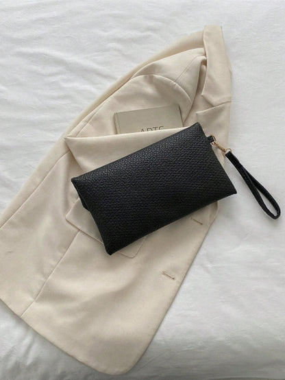 bolso clutch negro para mujer vista trasera sobre blazer claro