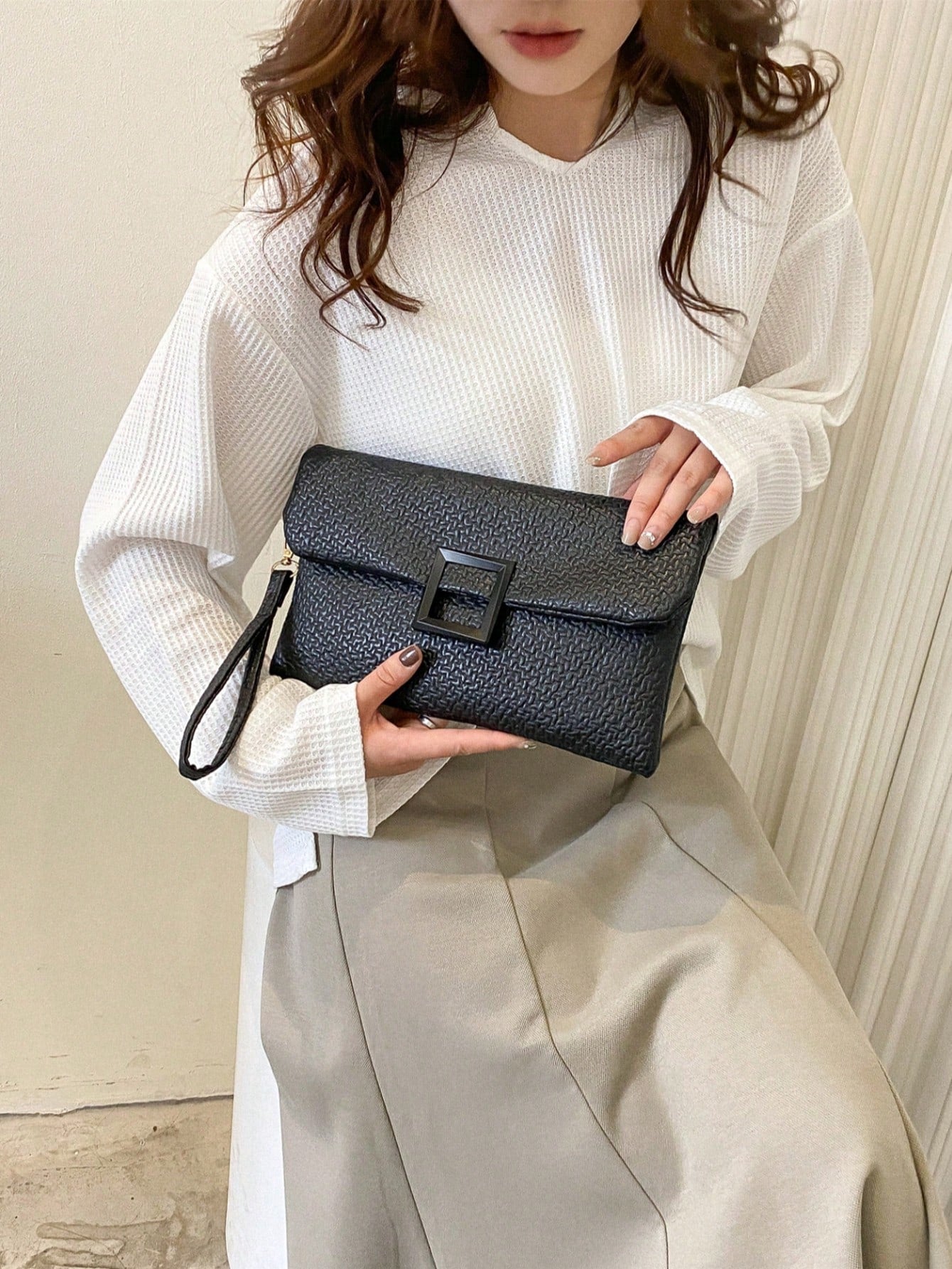 bolso clutch negro para mujer en uso con outfit casual