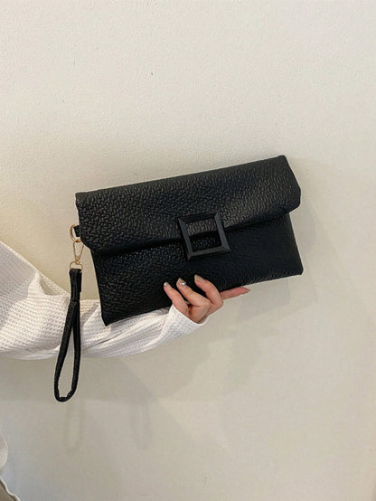 bolso clutch negro para mujer en mano con hebilla cuadrada
