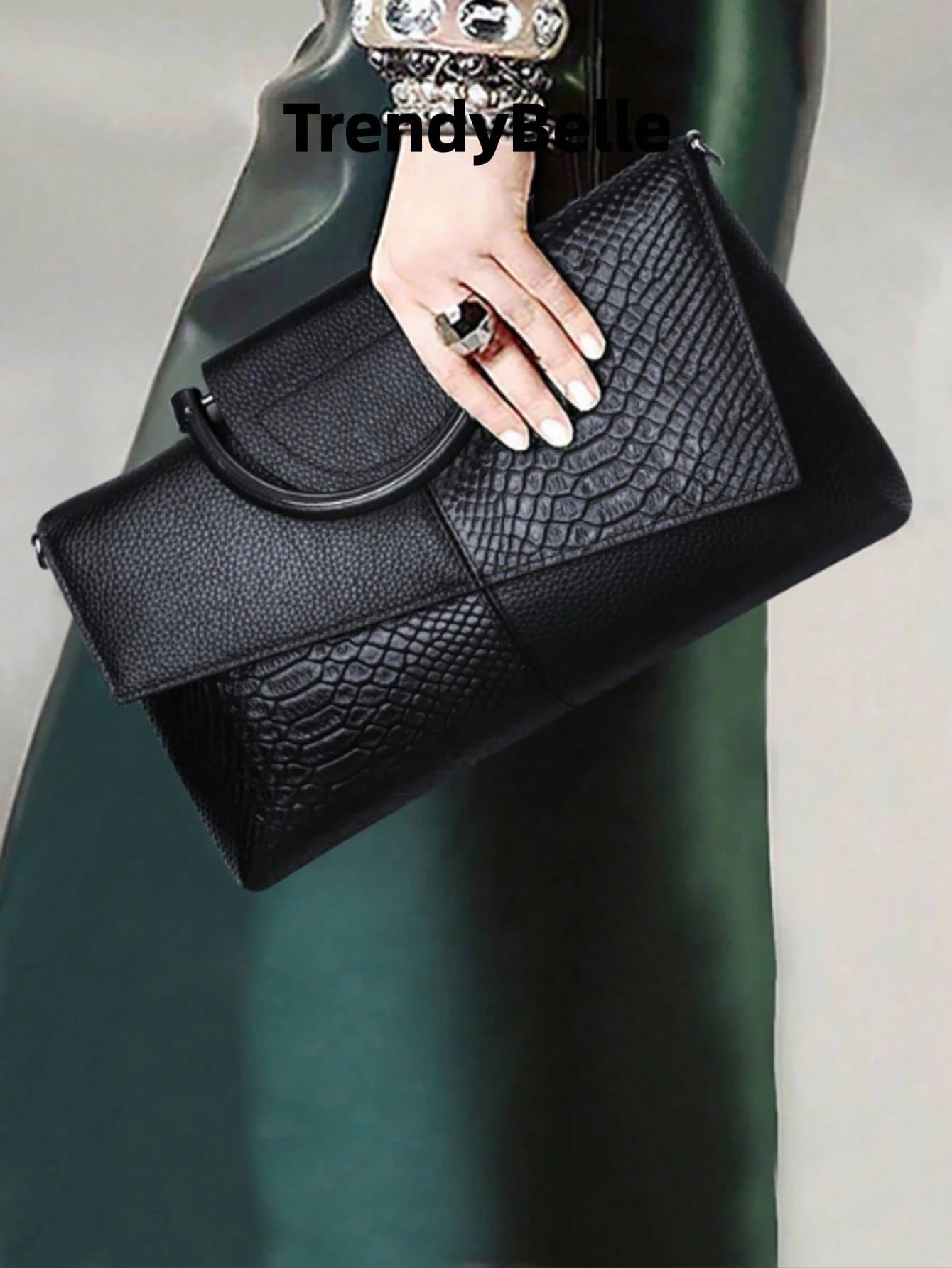 bolso de mano negro para mujer vista en uso con textura reptil
