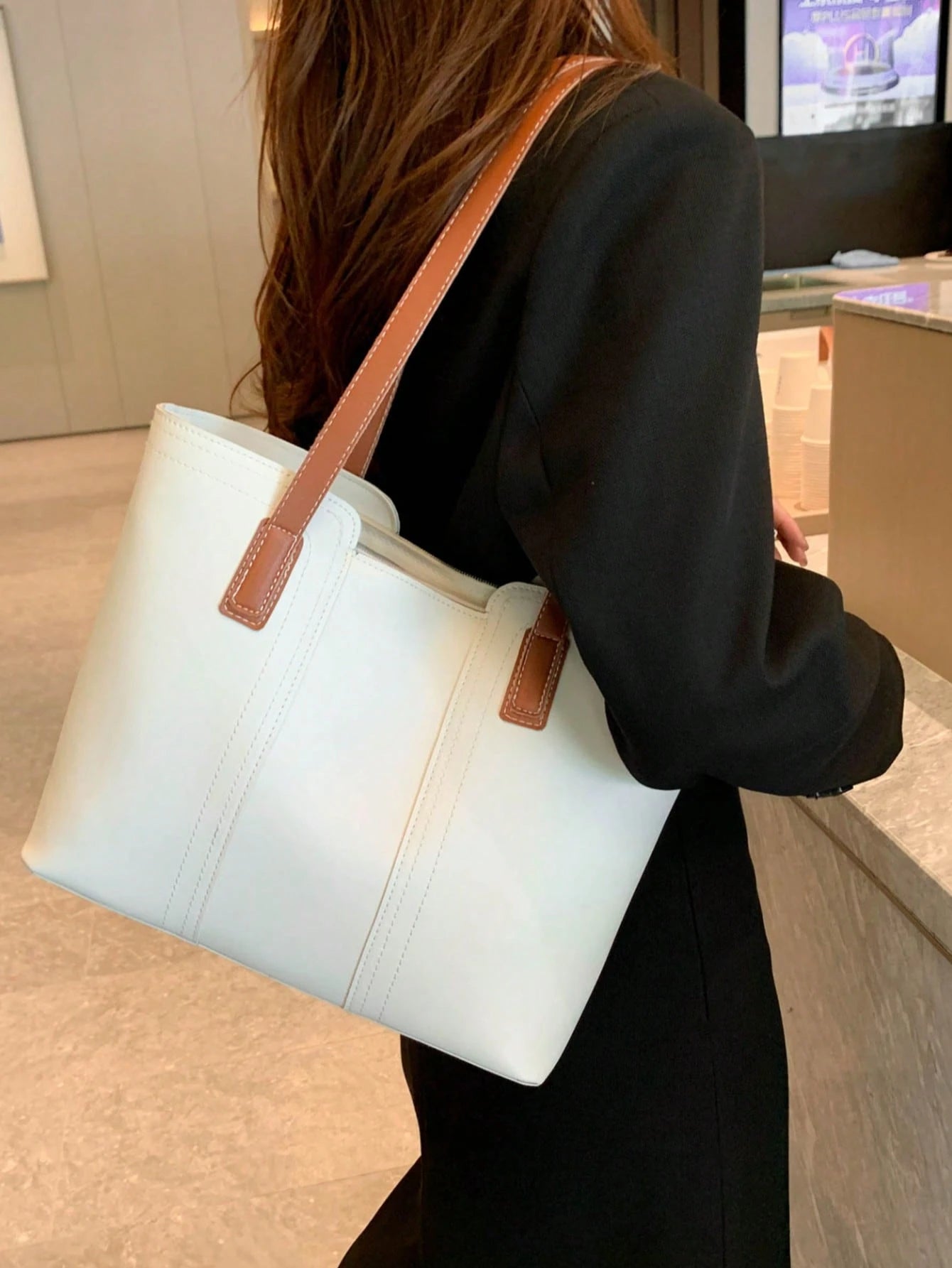 bolso tote blanco cargado al hombro