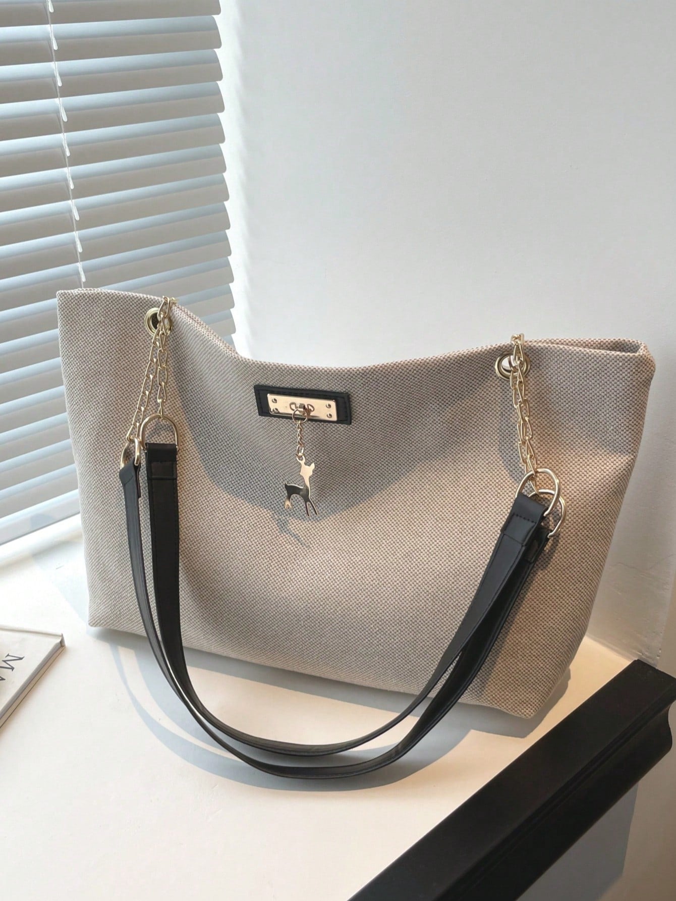 bolso beige tote para dama vista frontal con colgante decorativo