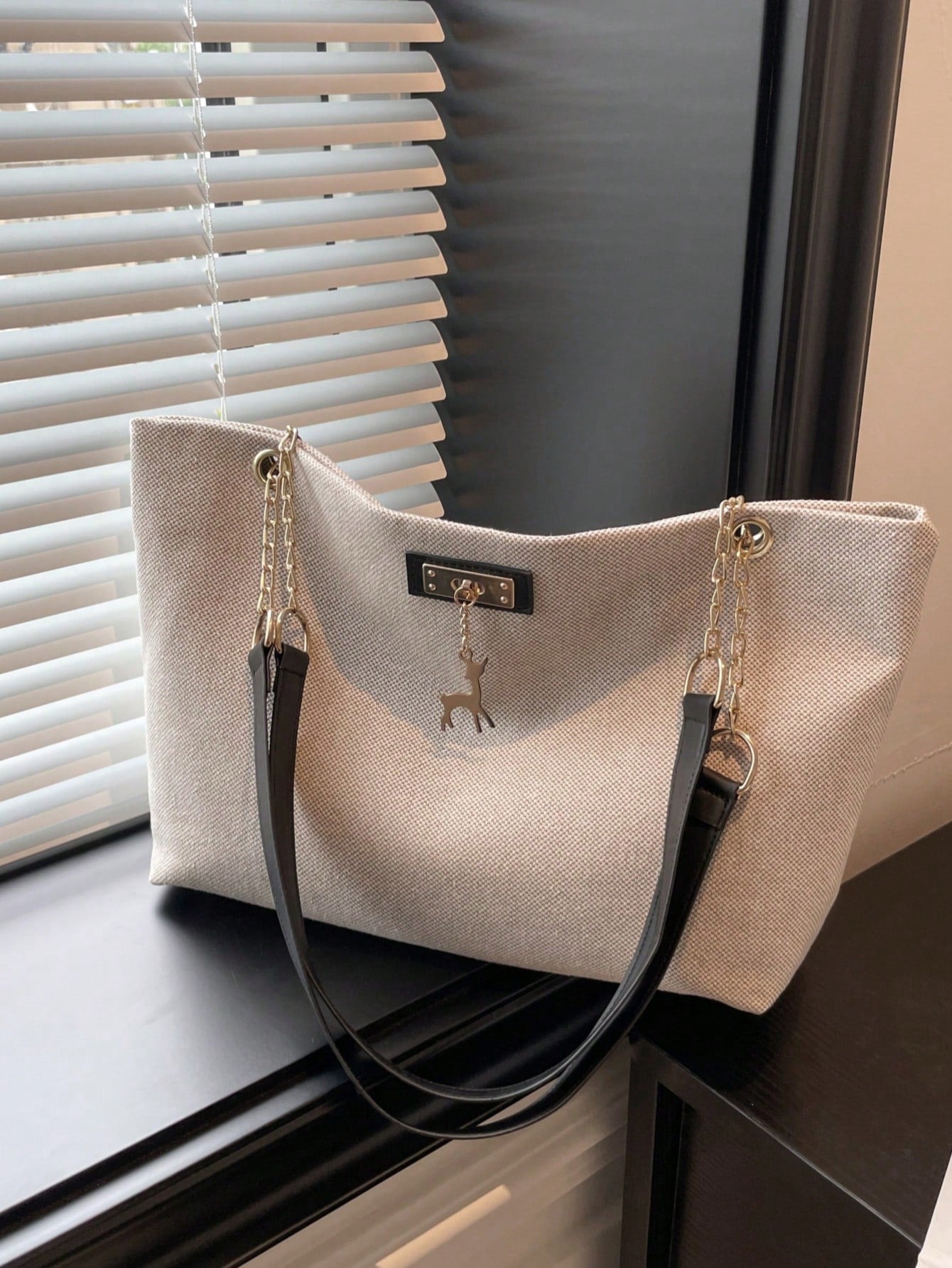 bolso beige tote para dama vista lateral con asas dobles negras