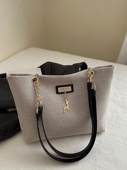 bolso beige tipo tote para dama con asas negras y cadena dorada