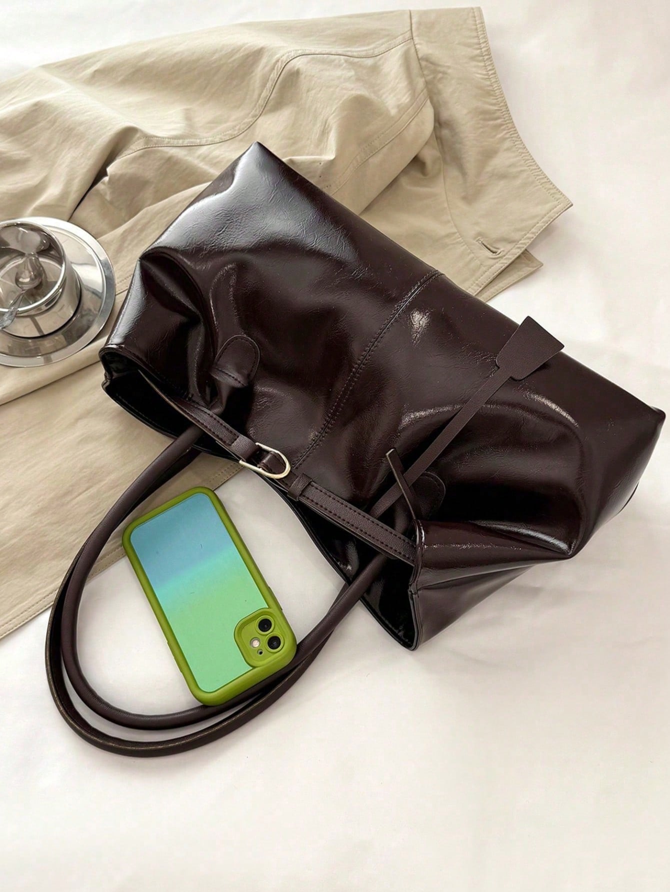 bolso café para mujer detalle del acabado brillante y hebilla
