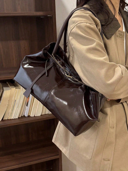 bolso café para mujer vista de hombro con acabado tipo charol