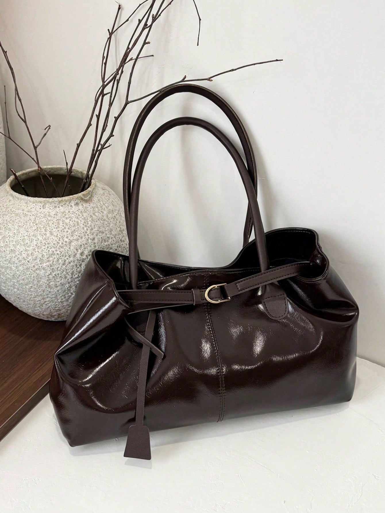 bolso café para mujer vista frontal con acabado brillante
