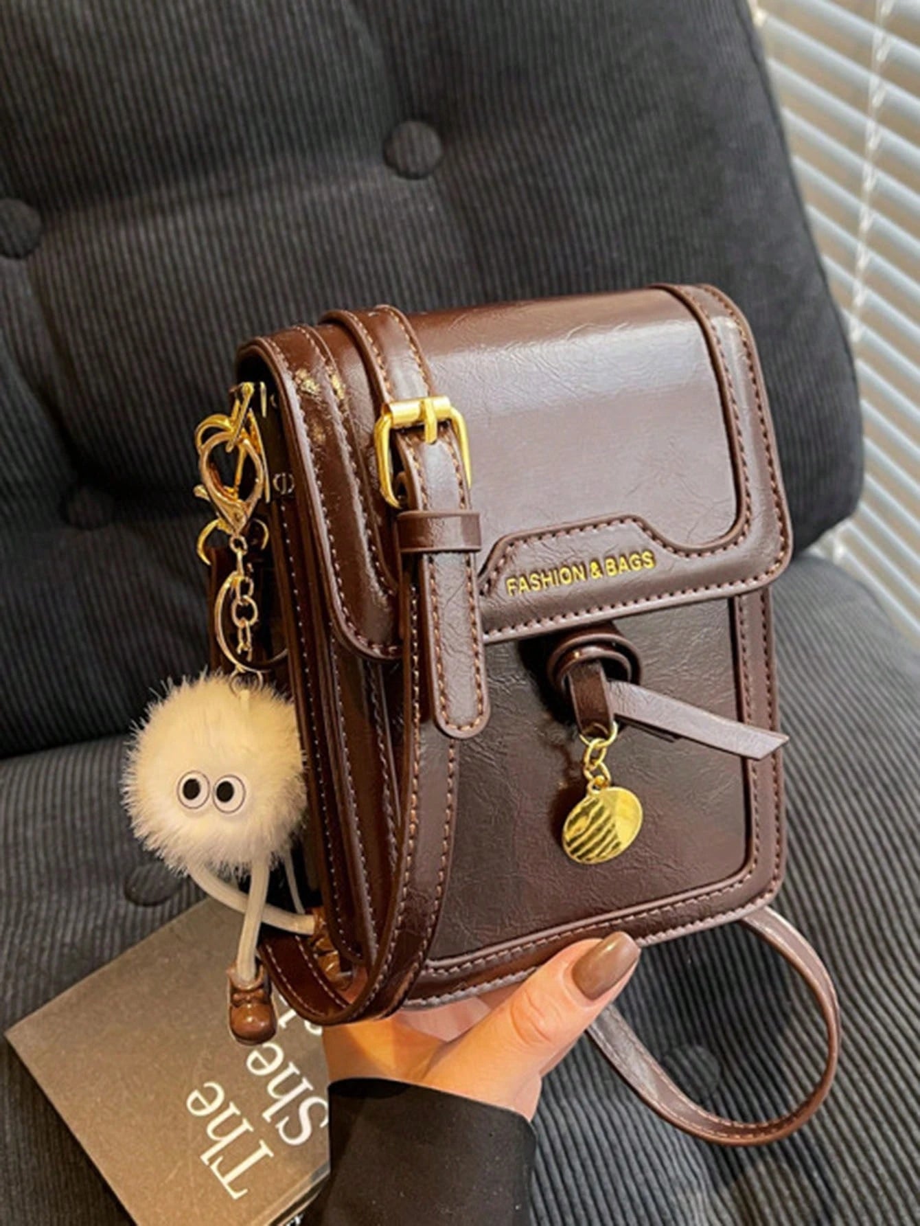Bolso crossbody café para mujer vista frontal con colgante decorativo