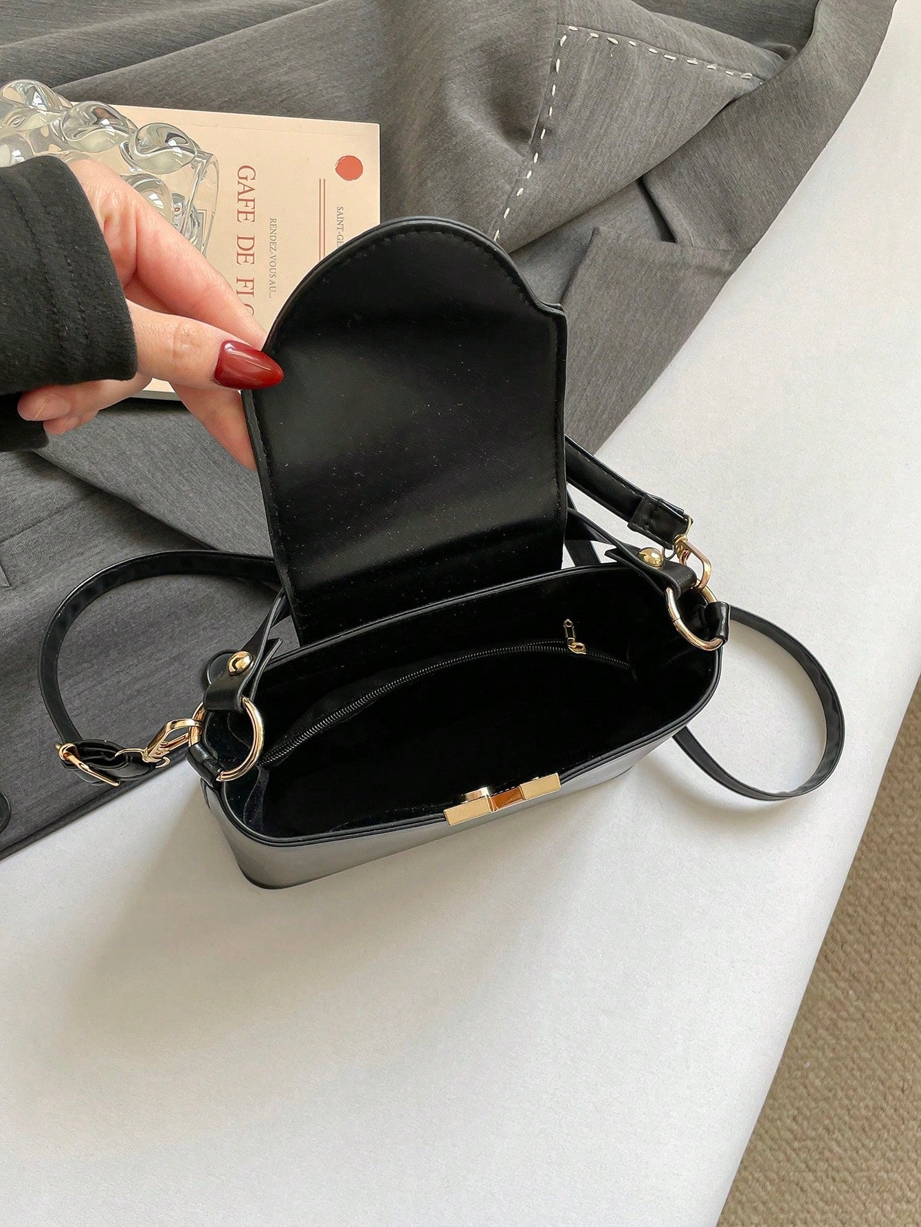 bolso cuadrado negro para mujer vista interior con solapa abierta
