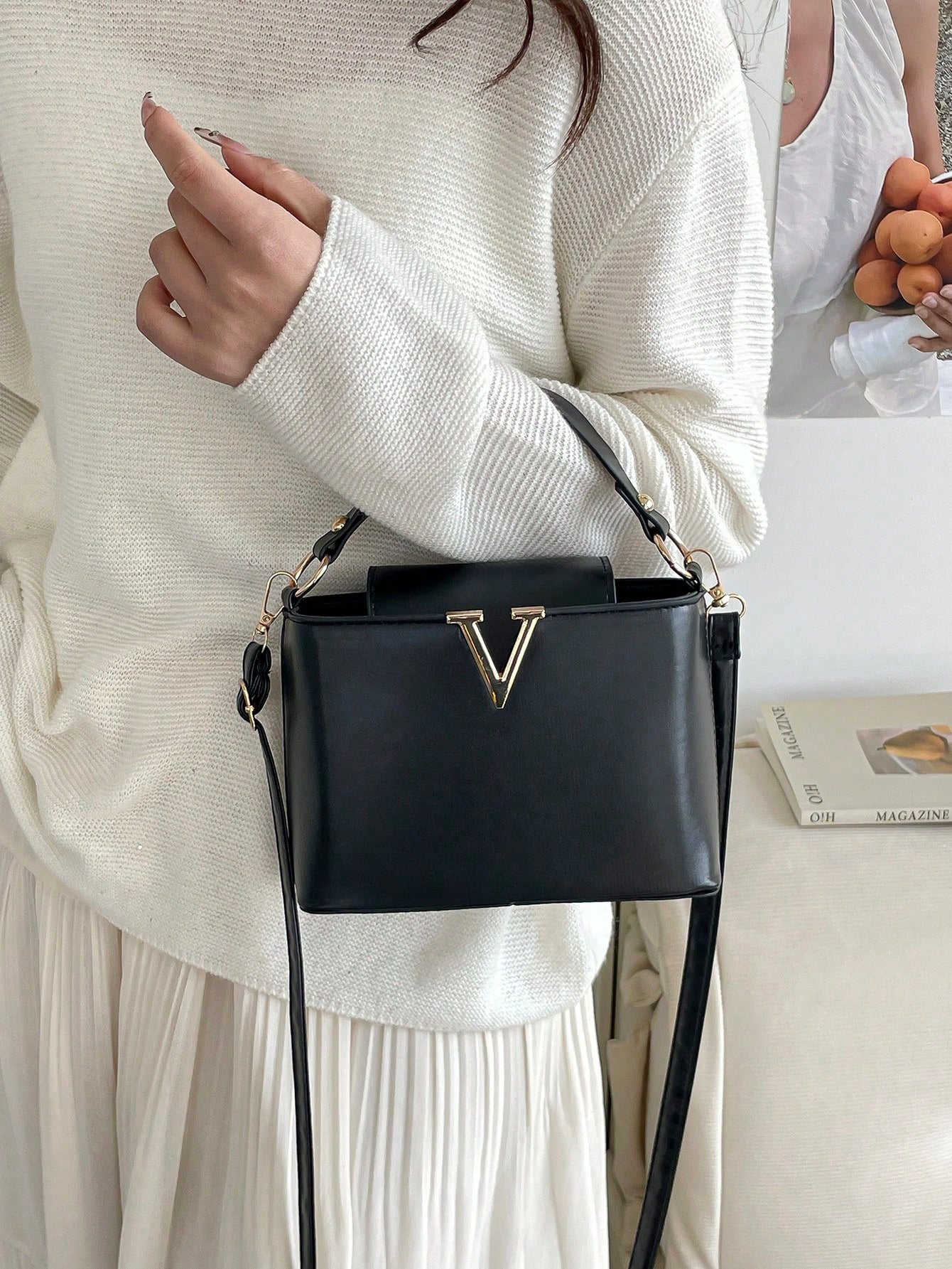 bolso cuadrado negro para mujer uso al hombro con suéter blanco
