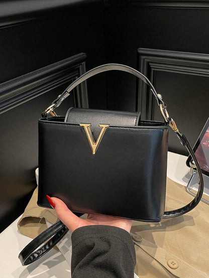 bolso cuadrado negro para mujer vista frontal con herraje en V
